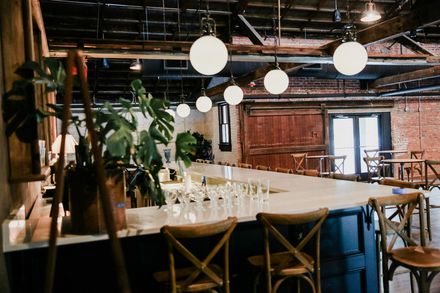 The Hall set for dinner beneath globe pendants